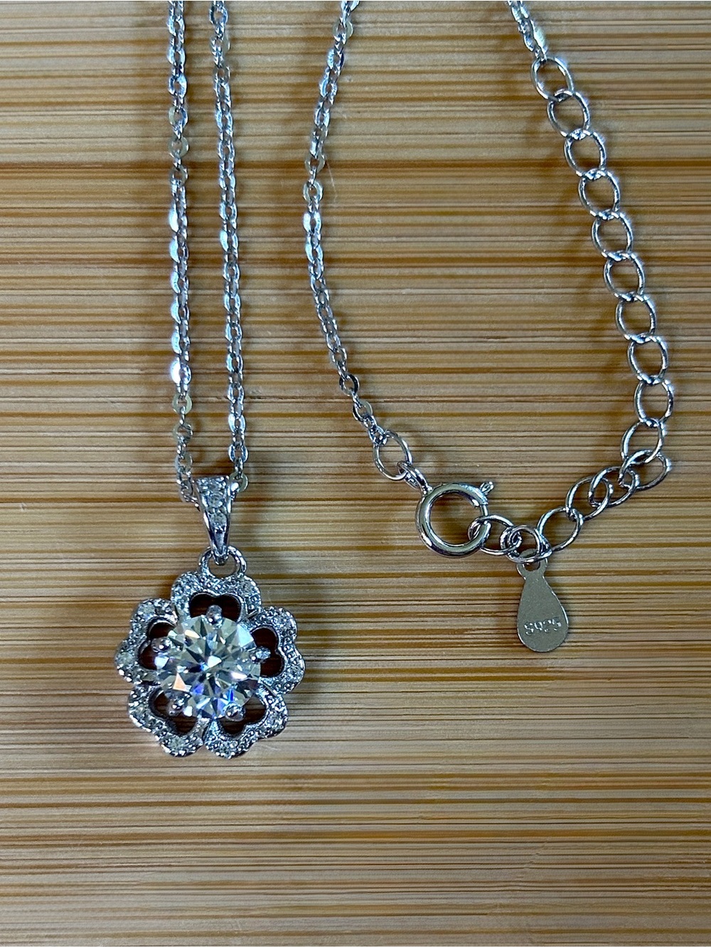 1ct Moissanite hibiscus necklace in sterling silver with white zircon accents!